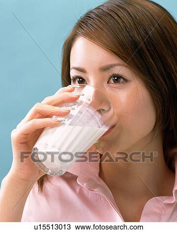 Stock Image - A Woman Drinking Milk, Side View . Fotosearch