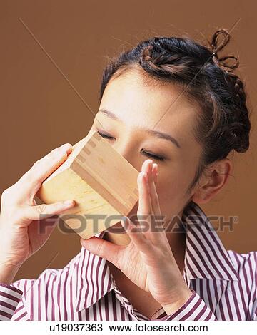 Stock Image - A Woman Drinking Sake, Front View. Fotosearch