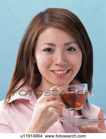 A Woman Drinking Tea, Smiling, Looking at Camera, Front View View Large Photo Image Picture - A Woman Drinking Tea, Smiling, Looking at Camera, Front View . Fotosearch