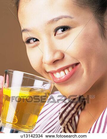 A Woman Drinking Tee, Looking at Camera, Side View, Close Up View Large Photo Image Picture - A Woman Drinking Tee, Looking at Camera, Side View, Close Up. Fotosearch