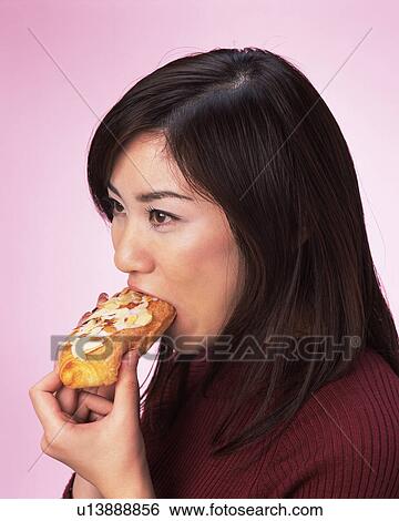 Stock Photograph - A Woman Eating Bread, Side Angle View . Fotosearch