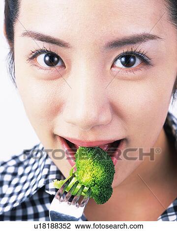 A Woman Eating Broccoli, Looking at Camera, Front View, Close Up, View Large Photo Image Stock Image - A Woman Eating Broccoli, Looking at Camera, Front View, Close Up,. Fotosearch