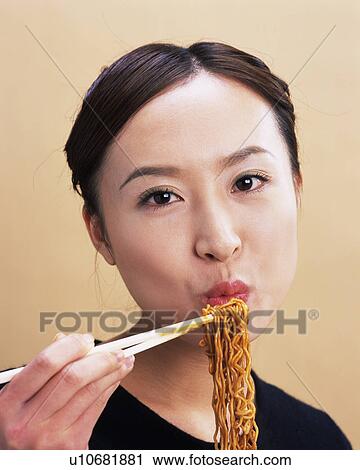 A Woman Eating Fried Noodle, Looking at Camera, Front View View Large Photo Image Stock Image - A Woman Eating Fried Noodle, Looking at Camera, Front View. Fotosearch