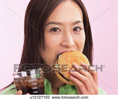 A Woman Eating Hamburger, Looking at Camera, Front View View Large Photo Image Stock Image - A Woman Eating Hamburger, Looking at Camera, Front View. Fotosearch
