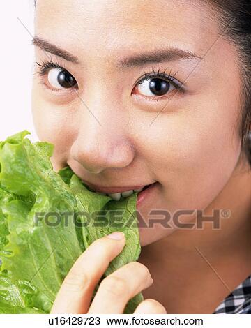 A Woman Eating Lettuce, Looking at Camera, Side View, Close Up View Large Photo Image Stock Image - A Woman Eating Lettuce, Looking at Camera, Side View, Close Up. Fotosearch