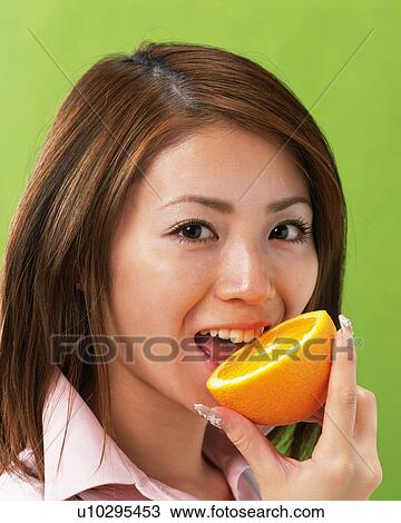 A Woman Eating Orange, Looking at Camera, Side View, View Large Photo Image Stock Image - A Woman Eating Orange, Looking at Camera, Side View, . Fotosearch
