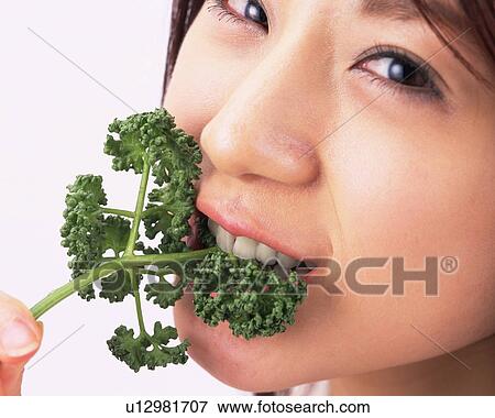 A Woman Eating Parsley, Looking at Camera, Close Up, Side View View Large Photo Image Stock Photo - A Woman Eating Parsley, Looking at Camera, Close Up, Side View. Fotosearch