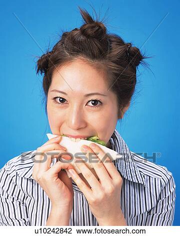 A Woman Eating Sandwich, Looking at Camera, Front View View Large Photo Image Stock Image - A Woman Eating Sandwich, Looking at Camera, Front View. Fotosearch