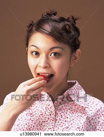 A Woman Eating Tomato, Looking at Camera, Front View View Large Photo Image Stock Image - A Woman Eating Tomato, Looking at Camera, Front View. Fotosearch