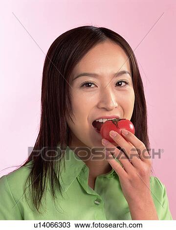 A Woman Eating Tomato, Looking at Camera, Front View View Large Photo Image Stock Image - A Woman Eating Tomato, Looking at Camera, Front View . Fotosearch
