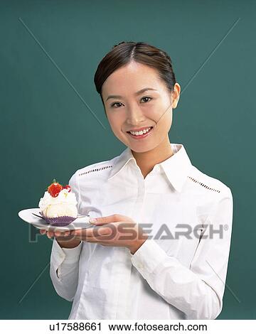 A Woman Holding a Cake On a Plate, Smiling, Looking at Camera, Front View, View Large Photo Image Stock Image - A Woman Holding a Cake On a Plate, Smiling, Looking at Camera, Front View, . Fotosearch