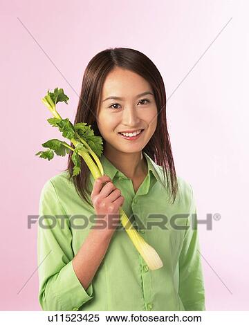 A Woman Holding Celery, Smiling, Looking at Camera, Front View View Large Photo Image Stock Photography - A Woman Holding Celery, Smiling, Looking at Camera, Front View. Fotosearch