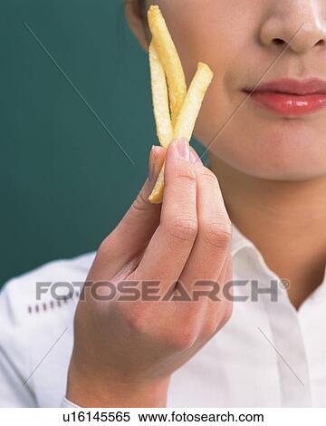 Stock Photography - A Woman Holding Chips, Close Up. Fotosearch