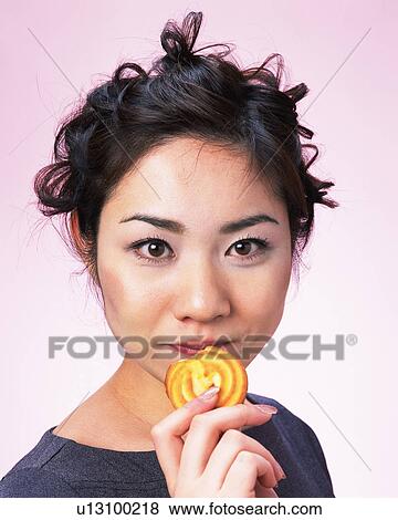 A Woman Holding Cookie, Looking at Camera, Front View, View Large Photo Image Stock Photo - A Woman Holding Cookie, Looking at Camera, Front View, . Fotosearch