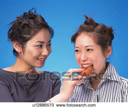 Two Young Women Eating Doughnut, Front View, View Large Photo Image Stock Image - Two Young Women Eating Doughnut, Front View,. Fotosearch