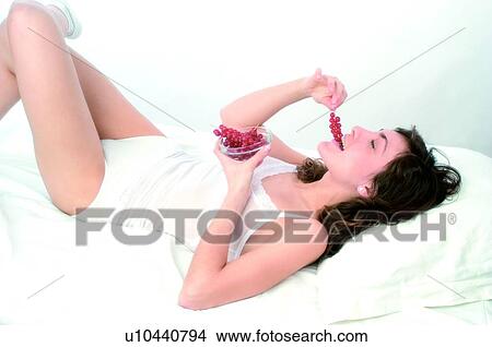 Picture - Woman, Brown hair, Beauty, White undershit, White, Red Currant Berry, Opening mouth. Fotosearch