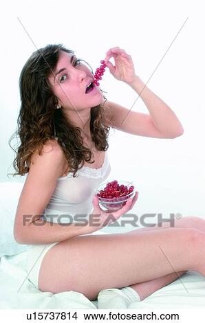 Picture - Woman, Brown hair, Beauty, White undershit, White, Red Currant Berry, Opening mouth. Fotosearch