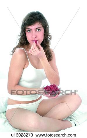 Stock Image - Woman, Brown hair, Beauty, White undershit, White, Red Currant Berry, Opening mouth. Fotosearch