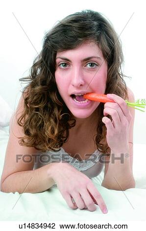 Woman, Brown hair, Beauty, White undershit, White, Carrot, Biting View Large Photo Image Stock Image - Woman, Brown hair, Beauty, White undershit, White, Carrot, Biting. Fotosearch