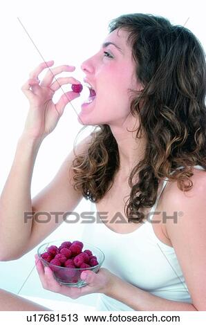 Stock Image - Woman, Brown hair, Beauty, White undershit, White, Red Currant Berry, Opening mouth. Fotosearch