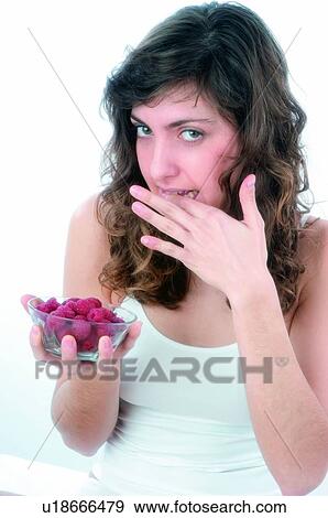 Stock Photo - Woman, Brown hair, Beauty, White undershit, White, Red Currant Berry, Opening mouth. Fotosearch