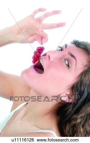 Stock Photograph - Woman, Brown hair, Beauty, White undershit, White, Red Currant Berry, Opening mouth. Fotosearch