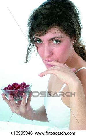 Stock Photograph - Woman, Brown hair, Beauty, White undershit, White, Red Currant Berry, Opening mouth. Fotosearch