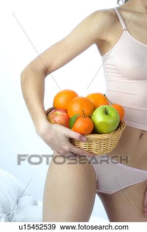 Stock Photo - Woman, Beauty, White undershit, Fruit, Basket, Apple, Orange. Fotosearch