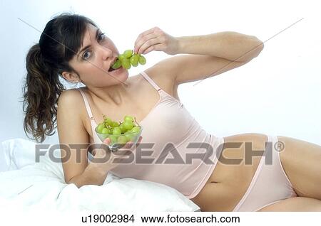 Picture - Woman, Brown Hair, Beauty, Eating, Fruit, Grapes, Mouth. Fotosearch