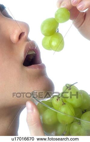 Stock Image - Woman, Brown Hair, Beauty, Eating, Fruit, Grapes, Mouth. Fotosearch