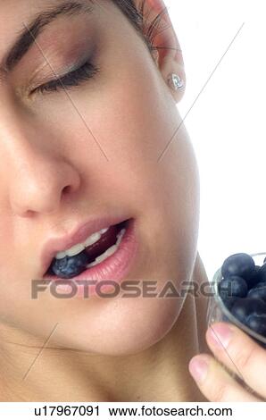 Stock Image - Woman, Brown Hair, Beauty, Eating, Fruit, Blueberry, Mouth. Fotosearch