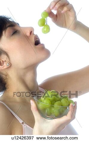 Stock Photo - Woman, Brown Hair, Beauty, Eating, Fruit, Grapes, Mouth. Fotosearch
