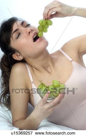 Stock Photo - Woman, Brown Hair, Beauty, Eating, Fruit, Grapes, Mouth. Fotosearch