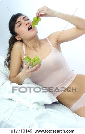 Stock Photo - Woman, Brown Hair, Beauty, Eating, Fruit, Grapes, Mouth. Fotosearch