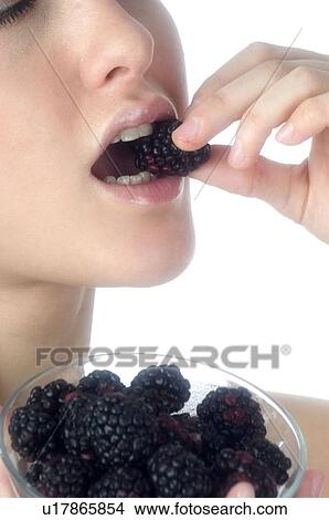 Picture - Woman, Brown Hair, Beauty, White undershit, Eating, Fruit, Mulberry. Fotosearch