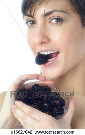 Stock Image - Woman, Brown Hair, Beauty, White undershit, Eating, Fruit, Mulberry. Fotosearch