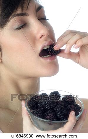 Stock Image - Woman, Brown Hair, Beauty, White undershit, Eating, Fruit, Mulberry. Fotosearch