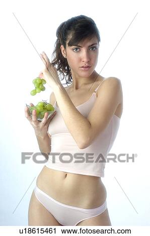 Stock Image - Woman, Brown Hair, Beauty, White undershit, Eating, Fruit, Grapes. Fotosearch