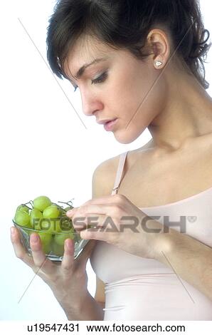 Stock Image - Woman, Brown Hair, Beauty, White undershit, Fruit, Grapes, Mouth. Fotosearch