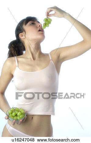 Stock Photo - Woman, Brown Hair, Beauty, White undershit, Eating, Fruit, Grapes. Fotosearch