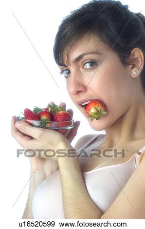 Stock Photo - Woman, Brown Hair, Beauty, White undershit, Eating, Fruit, Strawberry. Fotosearch