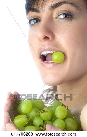 Stock Photo - Woman, Brown Hair, Beauty, White undershit, Eating, Fruit, Grapes. Fotosearch