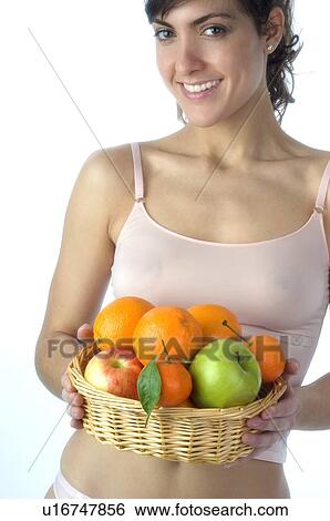 Stock Photograph - Woman, Brown Hair, Beauty, White undershit, Fruit, Basket, Apple. Fotosearch