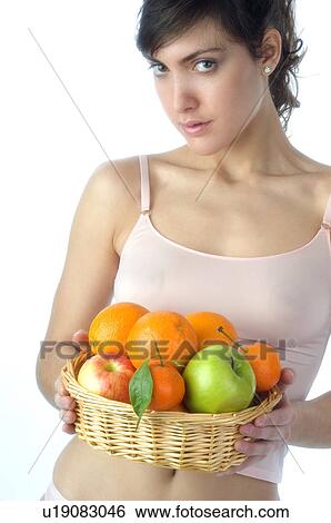 Stock Photograph - Woman, Brown Hair, Beauty, White undershit, Fruit, Basket, Apple. Fotosearch