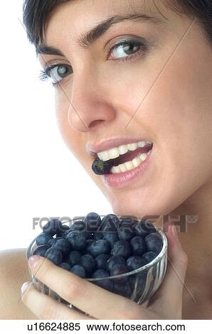 Stock Photography - Woman, Brown Hair, Beauty, White undershit, Eating, Fruit, Blueberry. Fotosearch