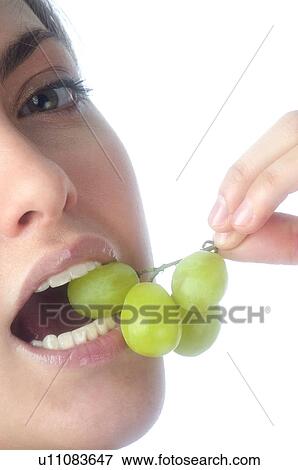 Stock Photo - Woman, Brown Hair, Ponytail, Beauty, White undershit, Eating, Fruit. Fotosearch