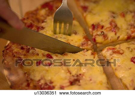 Stock Image - Cutting pizza. Lodz Central Poland. Fotosearch