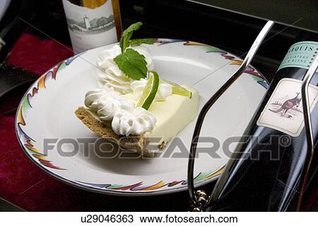 Stock Image - Key lime pie served with dessert wine. Fotosearch