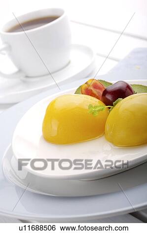 Stock Photograph - Arranged plate of fruit with vegetable garnish, in front of a cup of coffee. Fotosearch