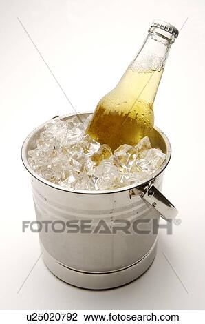 Stock Image - Bottle of unopened beer sitting in a bucket of ice. Fotosearch